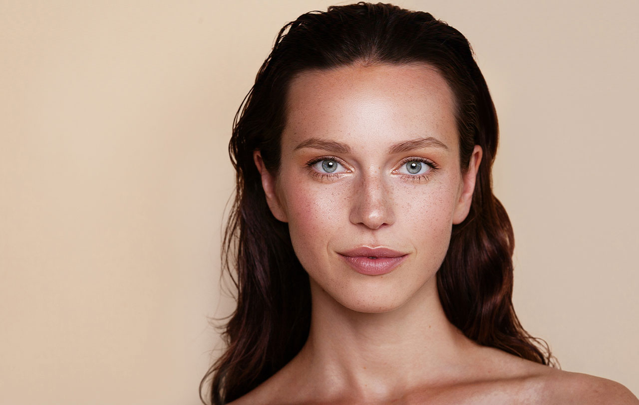 Young woman with dark hair and freckles